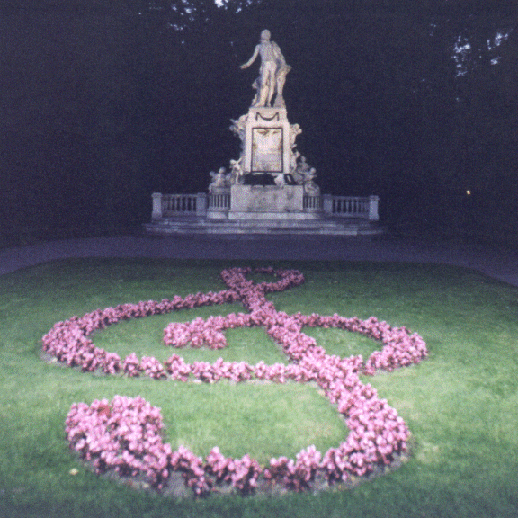 Mozart's statue in Vienna with treble clef floral display, Austria